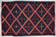 Striped navy blue blanket with three, different sized, alternating cross patterns: red crosses, red with white tips, and white with red tips, within a red and cream three-striped diamond pattern.