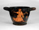 Rounded black vessel with thick handles and a cracked surface featuring orange illustrations of a running figure carrying a spiraling branch, wearing a headscarf and many layers of draped fabric.