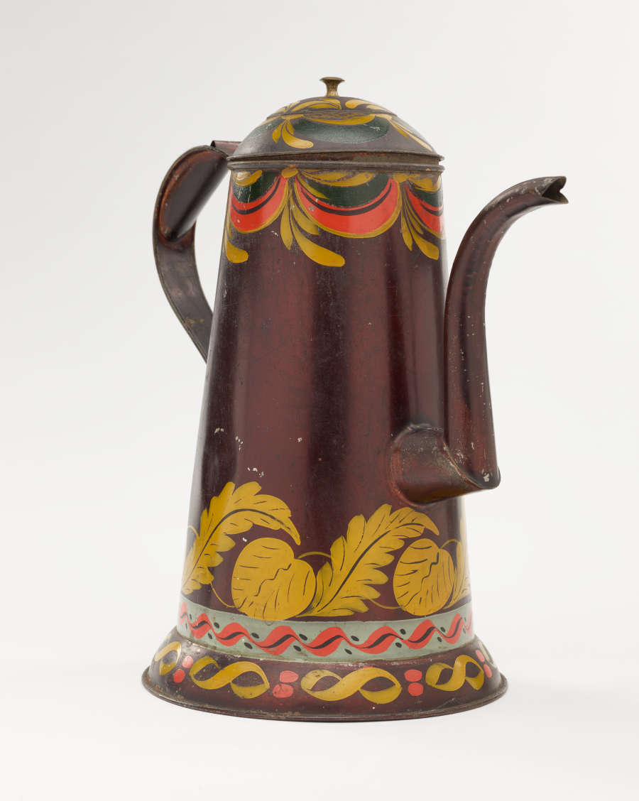 A shiny, brown colored coffee pot with yellow, white, and orange and abstract floral decoration. The spout has a right angle and then a curve.
