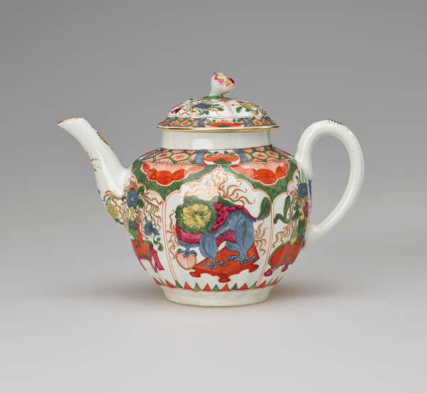 A white teapot with a handle, spout, lid and finial, with green, red, blue, pink, yellow and gilded decorations. The main vignite shows a dragon on a table.