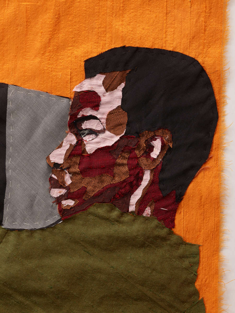 Textile of the side profile face of a medium-dark skinned person against an orange background. The face is contoured with large swaths of brown and red tones.
