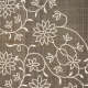 Closeup of a woven fabric with intricate white embroidery depicting flowing flowers and vines which curve around each other. Beneath is a gray backdrop with a textured grid.
