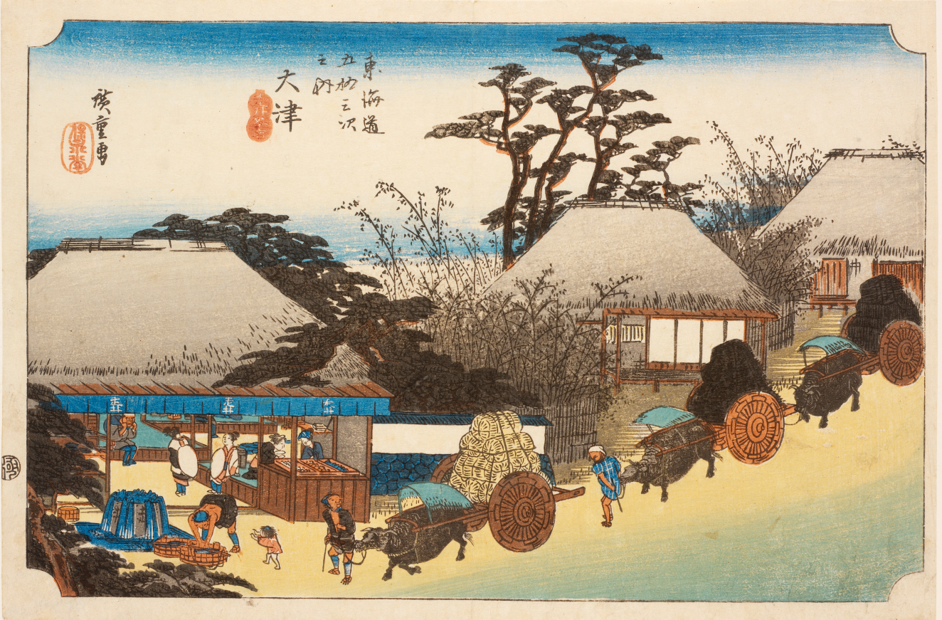 Oxen pulling carts with goods towards a busy market stall, surrounded by houses and set against a backdrop of tall trees and a blue sky.