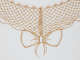 Detail of a piece of lace made of bee wings. The wings form a diamond-shaped pattern, with the outline of a bow extending from the bottom center.