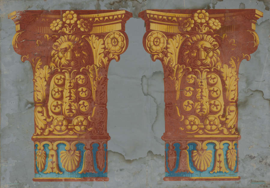 Wallpaper fragment featuring two vivid golden-yellow Corinthian columns adorned with lion heads, acanthus leaves, and florals with a teal stripe lining the base. The backdrop is gray and water stained.