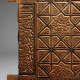 A close up of a carved wooden panel with intricate geometric star patterns and flowing calligraphic designs along the left edge.
