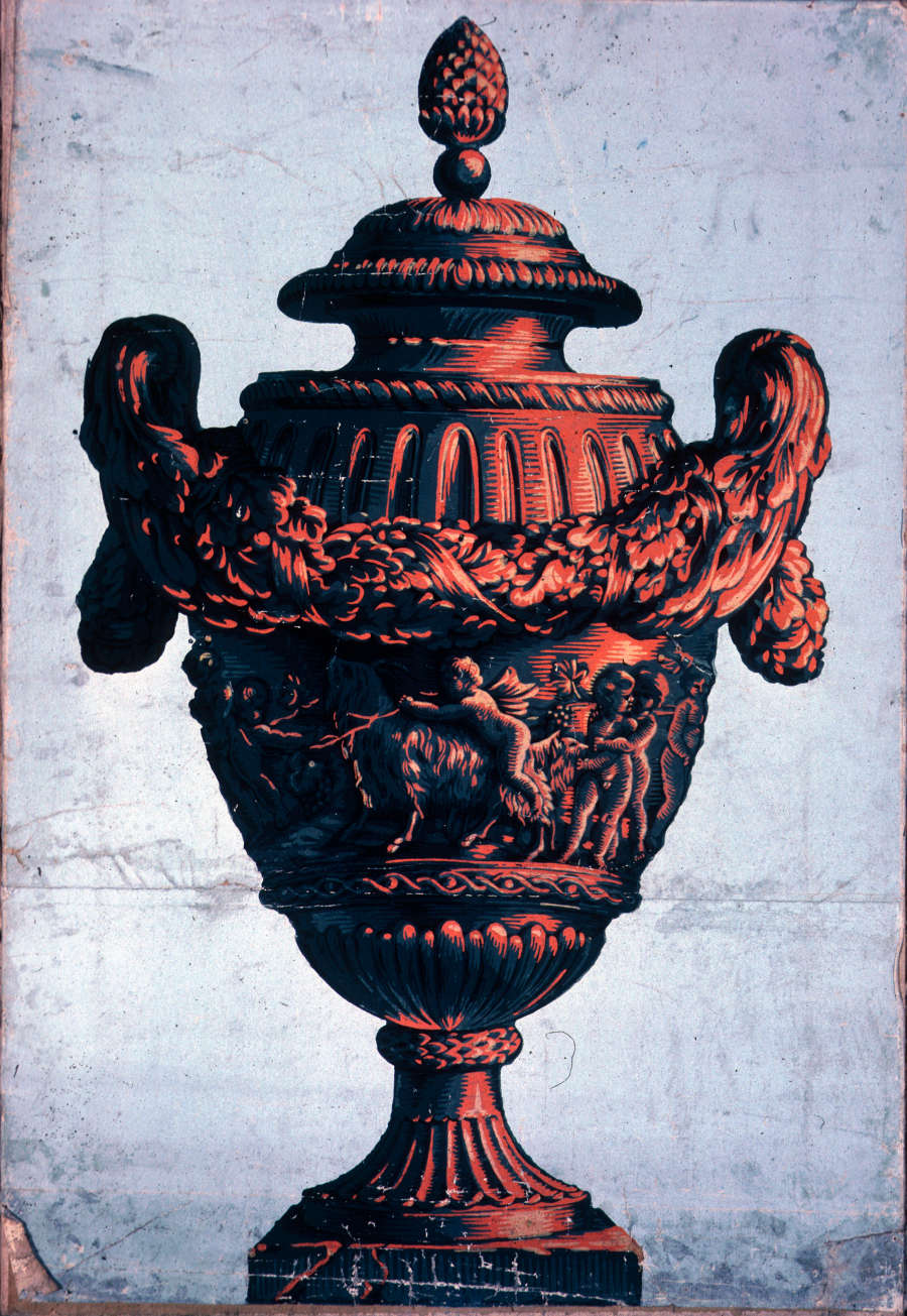 Bronze urn with leave-like handles that extend across its body. Below, a group of winged babies pull back a goat. Detailed carved lines surround the body and handles.