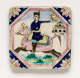 Square tile with triangular blue corners with floral motifs. Its center is framed by a pink octagon and features a man in blue riding a pink horse across green terrain.