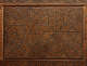 A carved wooden panel with intricate geometric star designs contained by a decorative rectangular border.