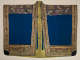 A richly decorated robe with broad sleeves, with intricate embroidery of cranes in flight, colorful blossoms, and geometric patterns against a shimmering gold border, framing a blue center. 