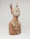 Side view of the bust, revealing that the headdress is composed of a bundle of sticks rising from behind the head. The sticks are placed into a narrow vessel attached to the head. 