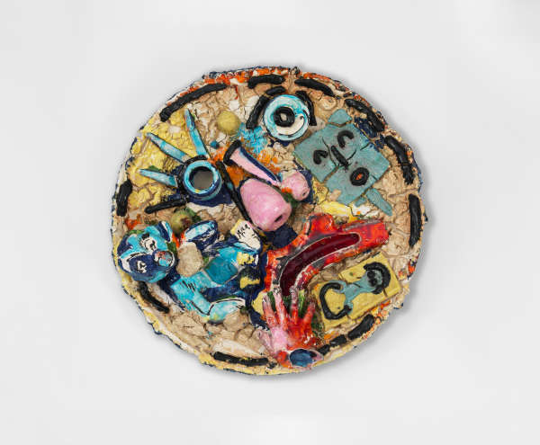 Ceramic disk with a cracked colorful surface showing a fragmentary frowning face with features made up of disjointed shapes and various symbols such as a blue baby and a red hand.