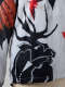 Detail of the jacket’s left lower side, showing a print-like black silhouette of an antlered animal below smaller red, cream, and black birds.