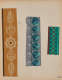 Three decorative strips. Left: Yellow and white intricate floral designs. Center: Teal leaf and white flower pattern gray backdrop. Right: Green strip with geometric diamond patterns and brown accents.